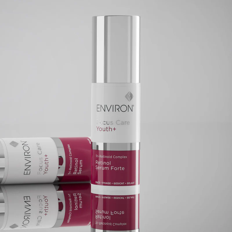 Bottle of Environ Retinol Serum and Retinol Serum Forte next to a model, highlighting Vitamin A anti-aging skincare benefits