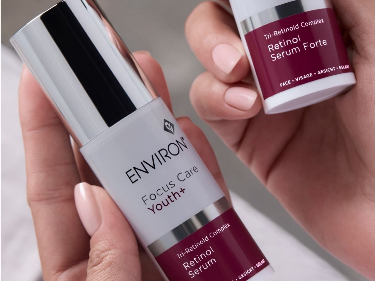 Bottle of Environ Retinol Serum and Retinol Serum Forte next to a model, highlighting Vitamin A anti-aging skincare benefits